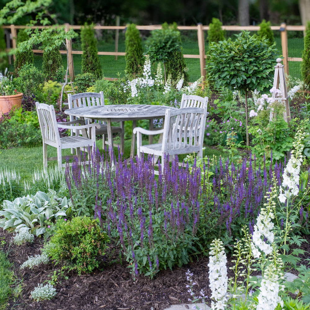 Teak dining set in a formal cottage garden