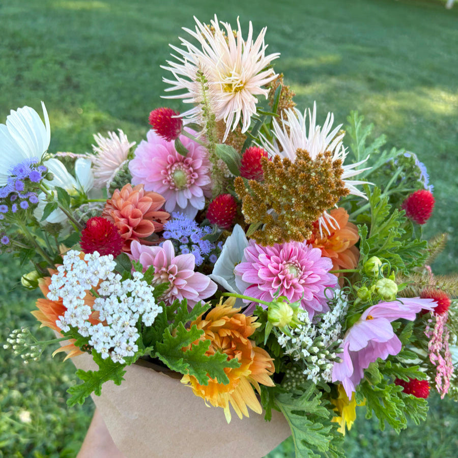 Bouquet of dahlias, yarrow, heirloom mums, amaranth, gomphrena, and ageratum in pink, blue, cherry red, white, and peach.