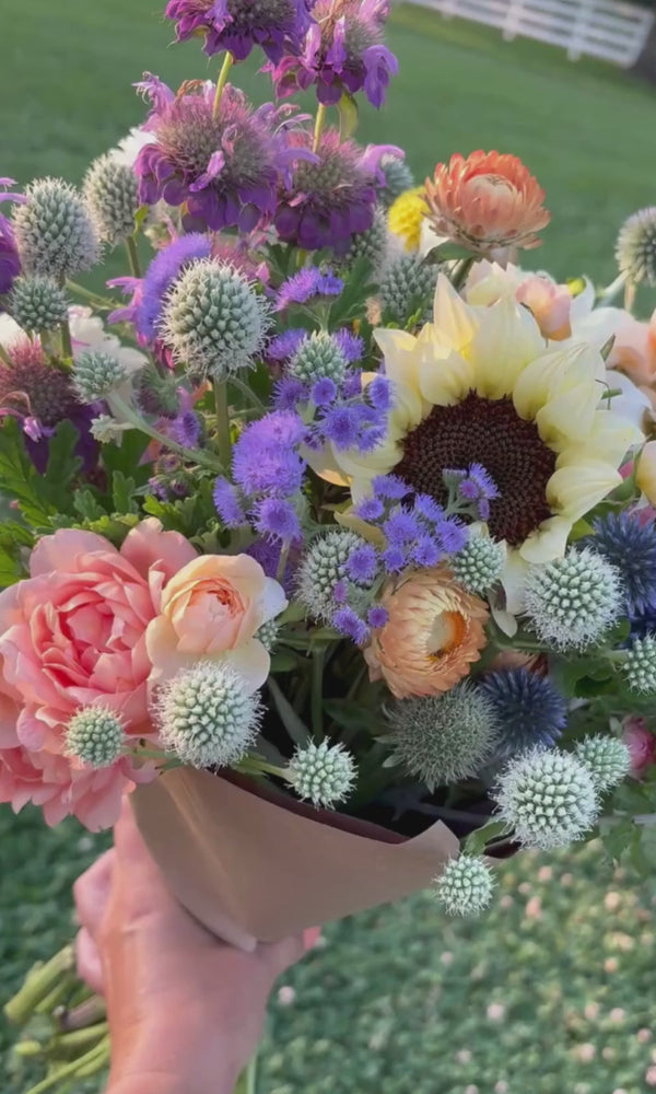 Bouquet of thistle, sunflowers, and roses
